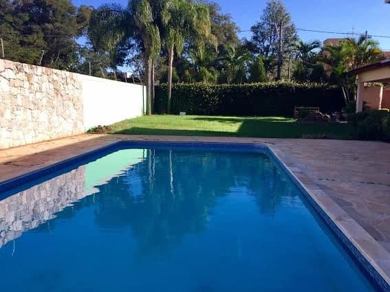 Piscina ao ar livre com jardim e deck de madeira