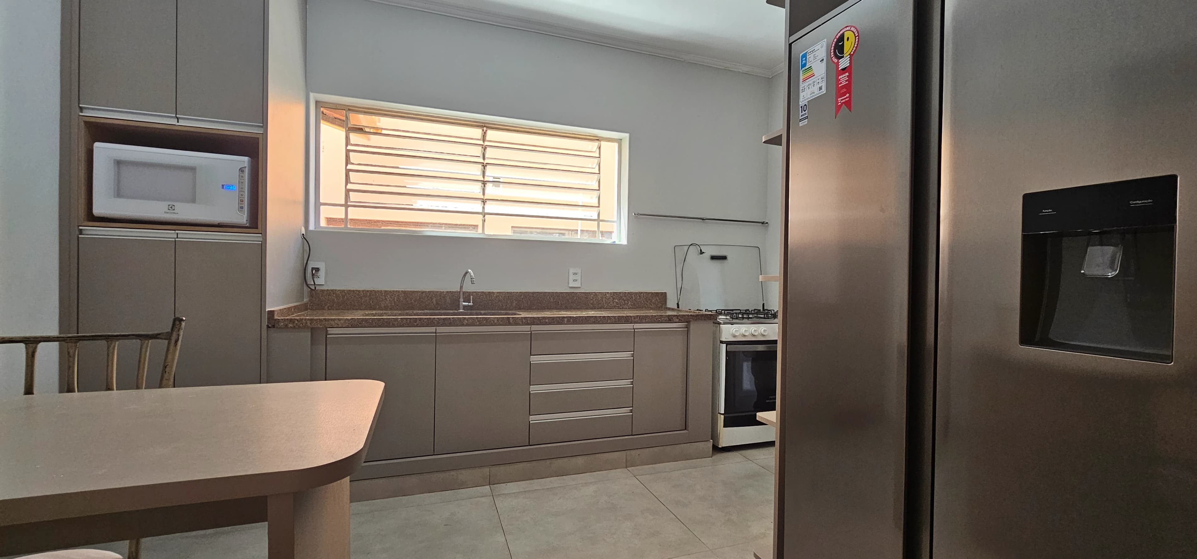 Cozinha equipada com geladeira, micro-ondas e armários